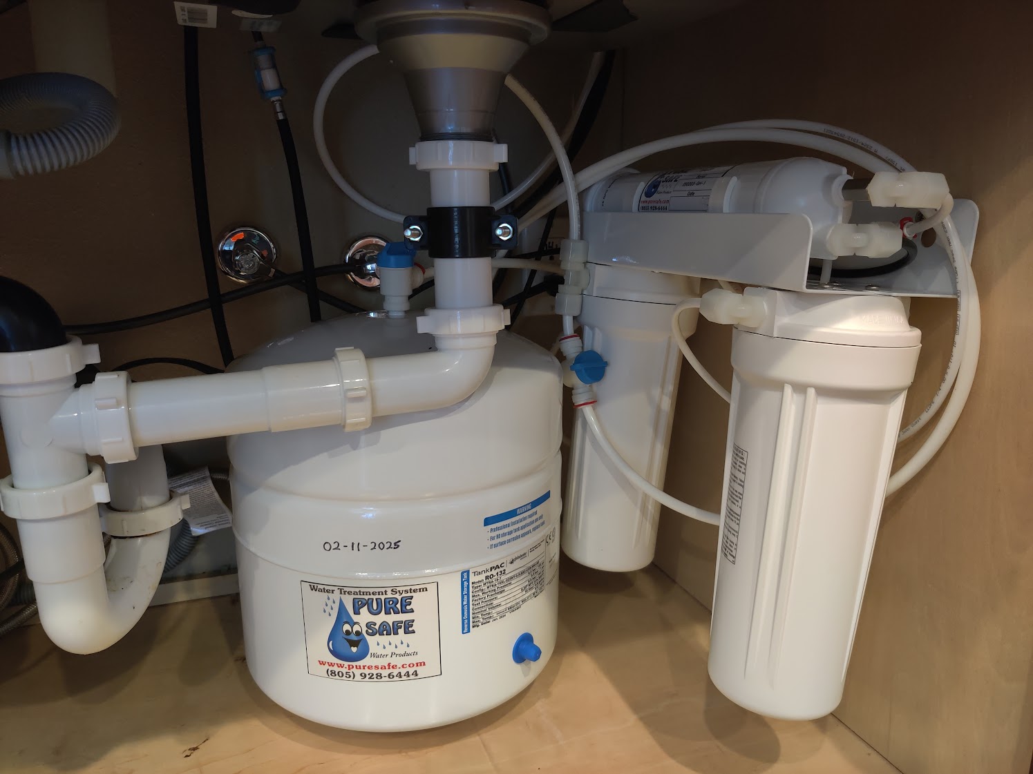 Reverse osmosis tank and filter housings installed beneath a sink