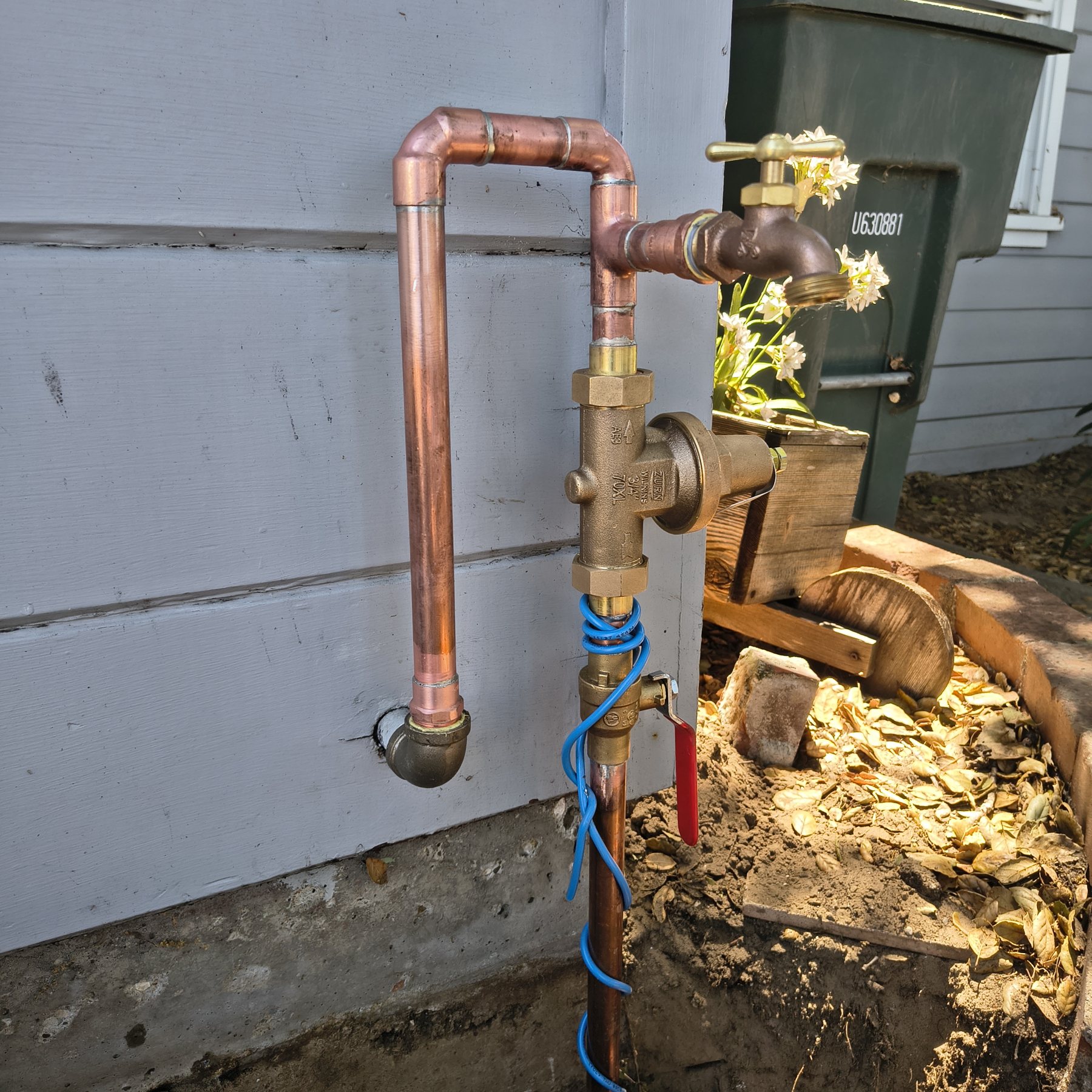 Copper shutoff valves and pressure regulator mounted outside a building