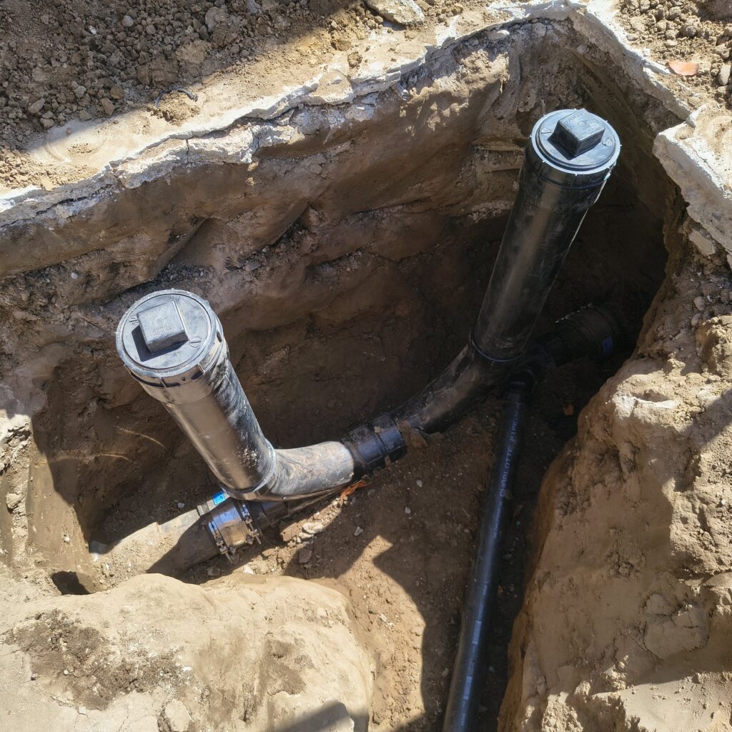 Sewer cleanout piping exposed in an excavation