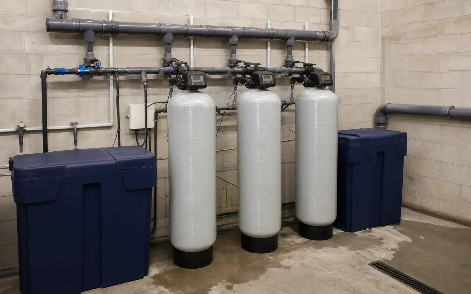 Commercial water softener system with multiple treatment tanks and professional plumbing