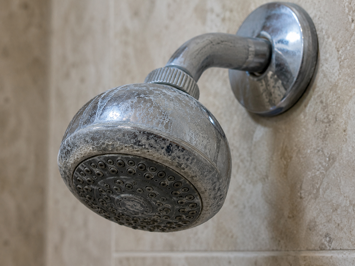 Hard water mineral scale buildup on a residential showerhead
