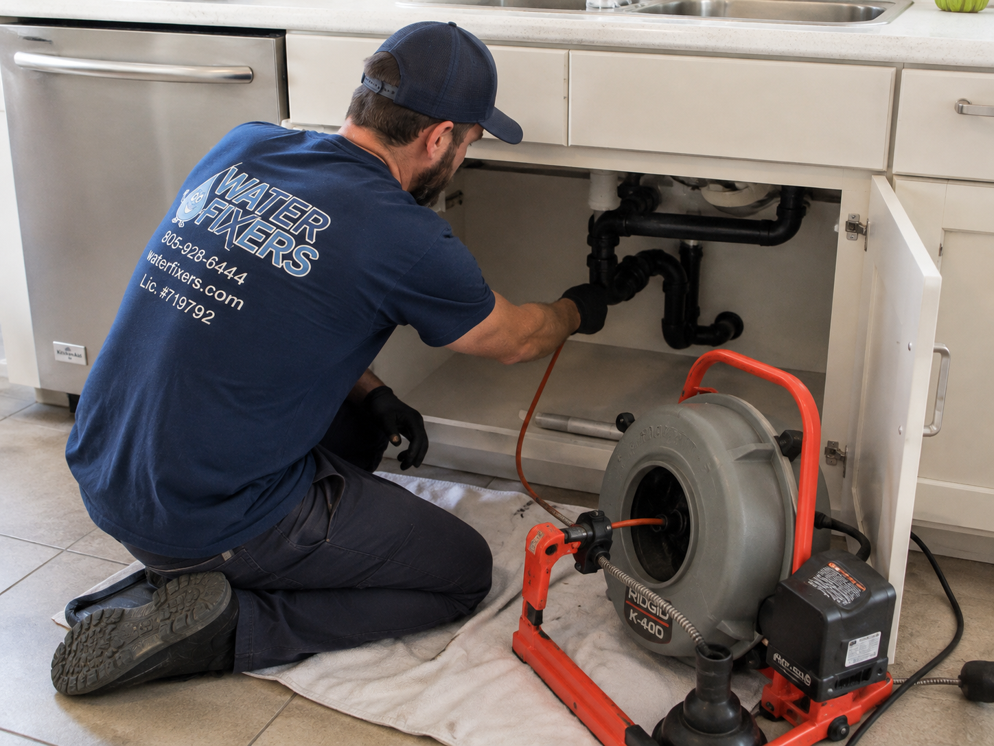 Water Fixers technician clearing a residential drain with professional drain-cleaning equipment
